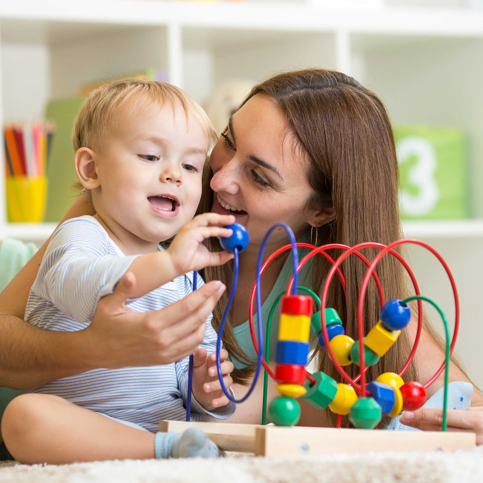 Mother and baby playing with a sensory toy 